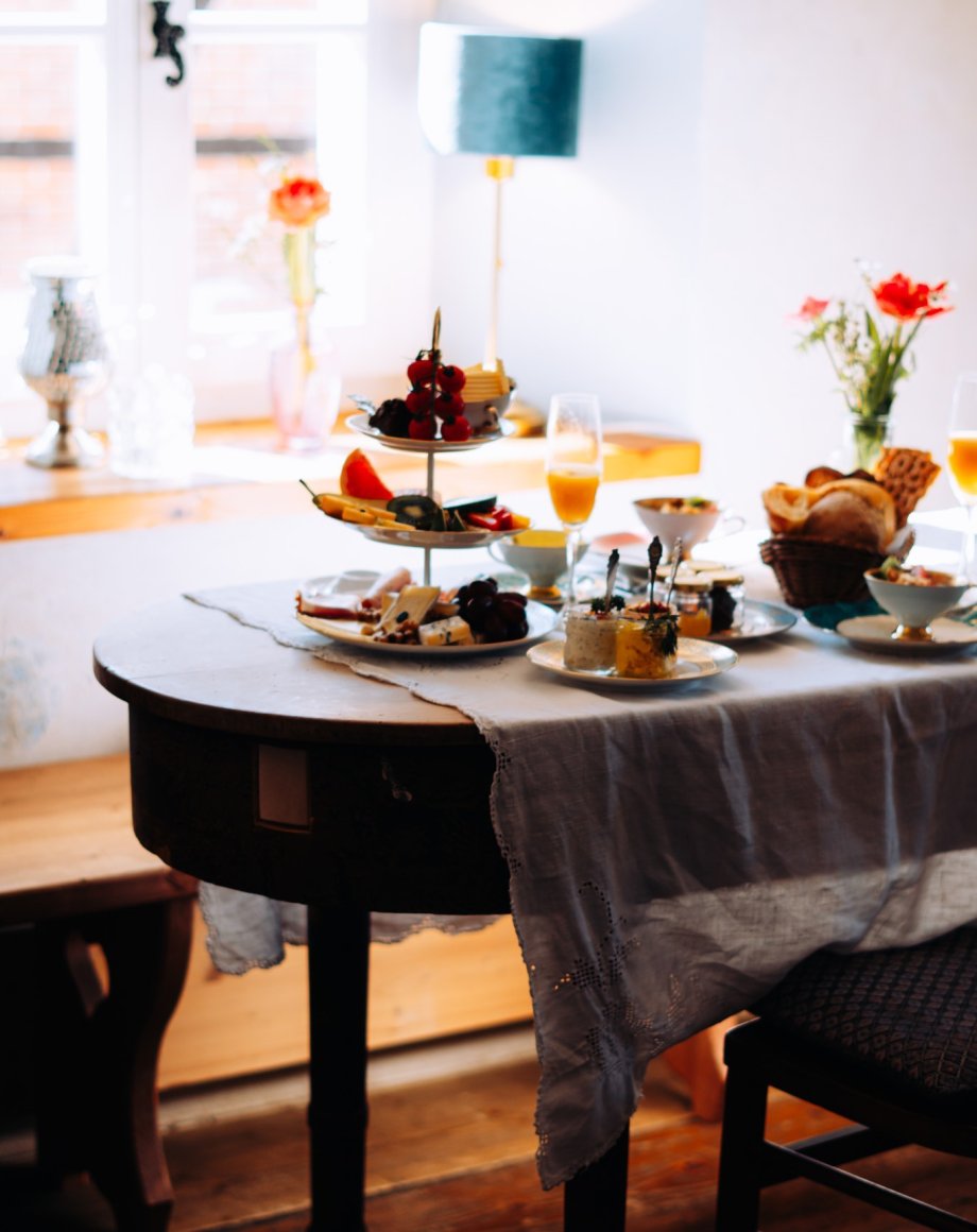 Ontbijtruimte in een hotel met linnen tafellinnen en gebloemd servies, door cestsjoukje