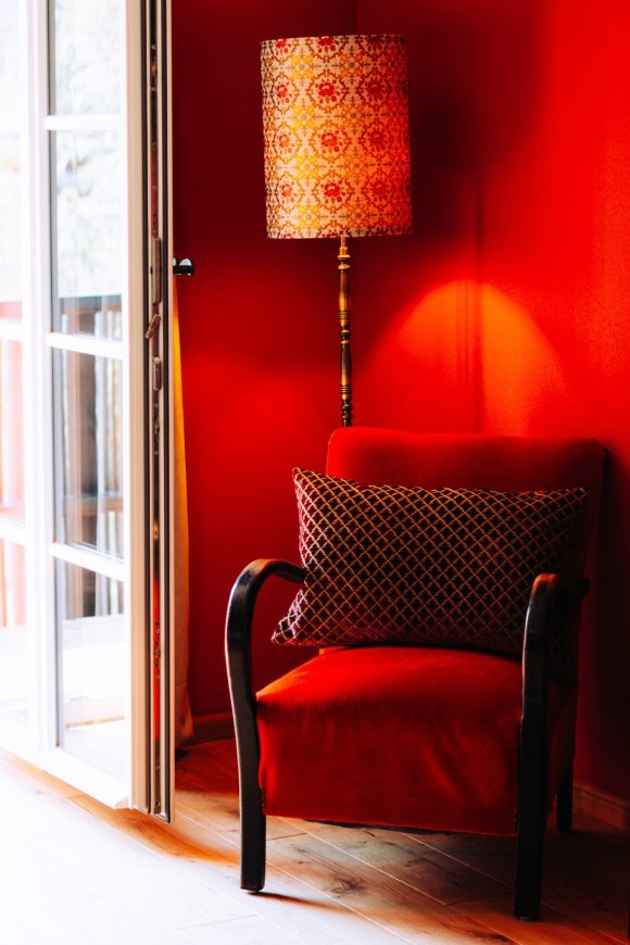 Warme rode zithoek met vintage fauteuil, boutique hotel interieur door cestsjoukje