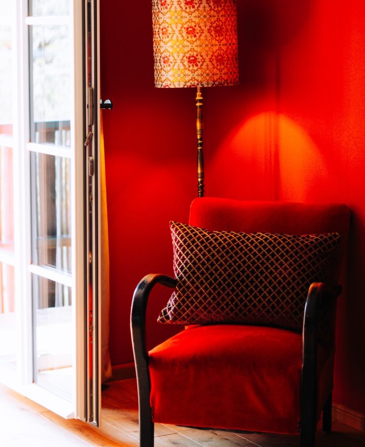 Warme rode zithoek met vintage fauteuil, boutique hotel interieur door cestsjoukje