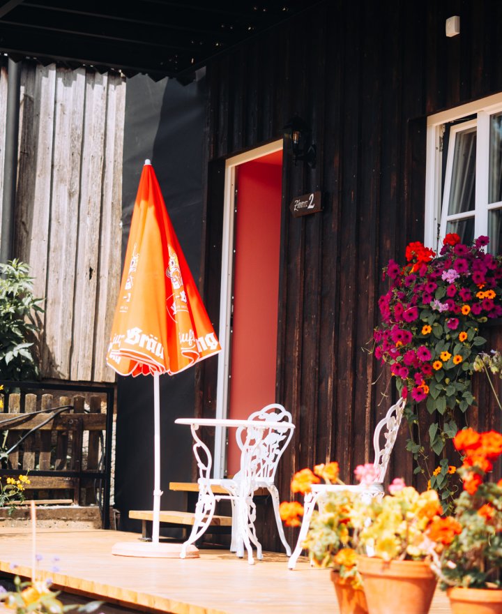 Terras bij het Holzhaus met witte bistromeubels en volop bloemen, door cestsjoukje