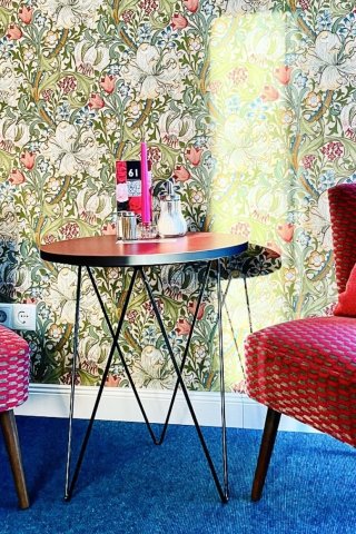 Cafe-interieur met Golden Lily behang van Morris & Co, twee framboosroze vintage fauteuils en een kobaltblauw tapijt, door cestsjoukje