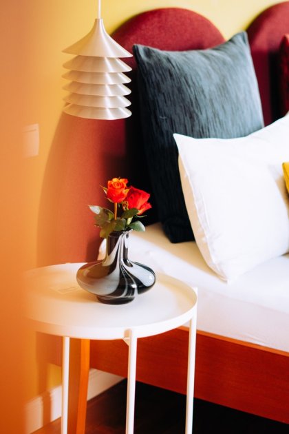 Hotelkamer met pagodelamp tegen een warme oranje wand, door cestsjoukje