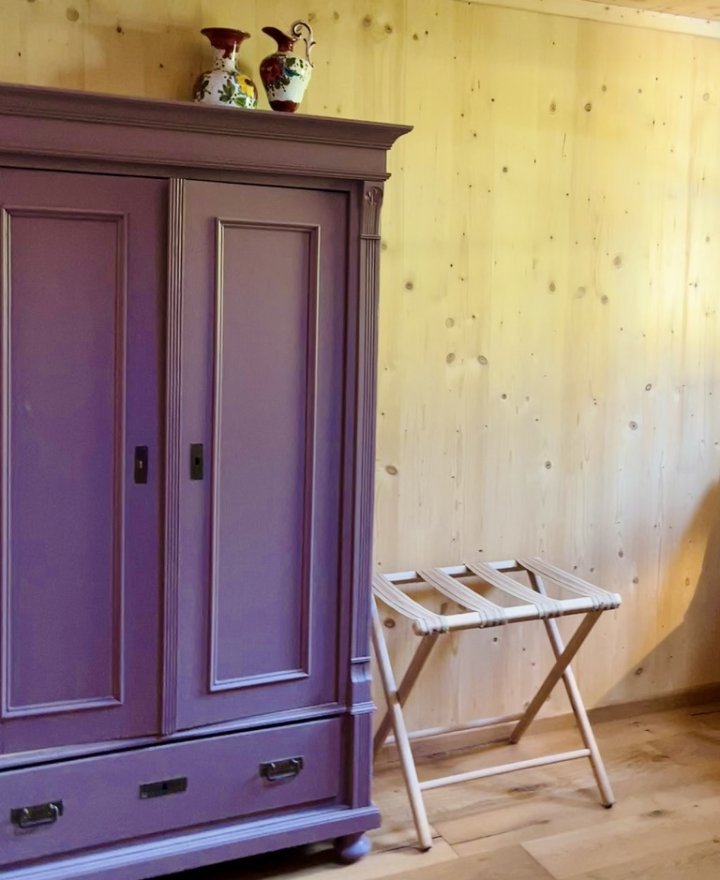 Antieke kast in Rosewood met bloemenvazen en bagagerek in een hotelkamer, hotelinterieur door cestsjoukje
